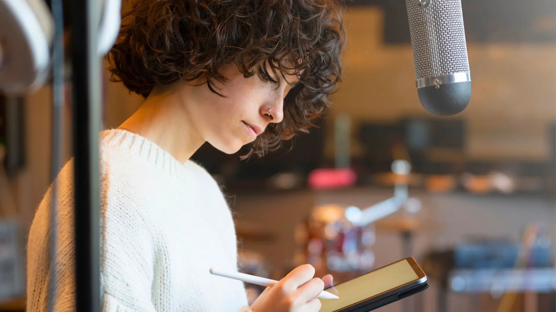 Person writing on iPad in a recording studio