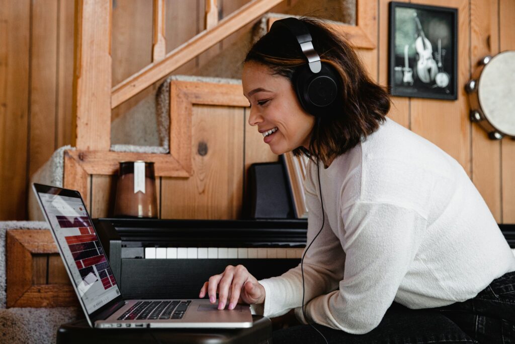 a voice actress sitting in front of a laptop wearing headphones